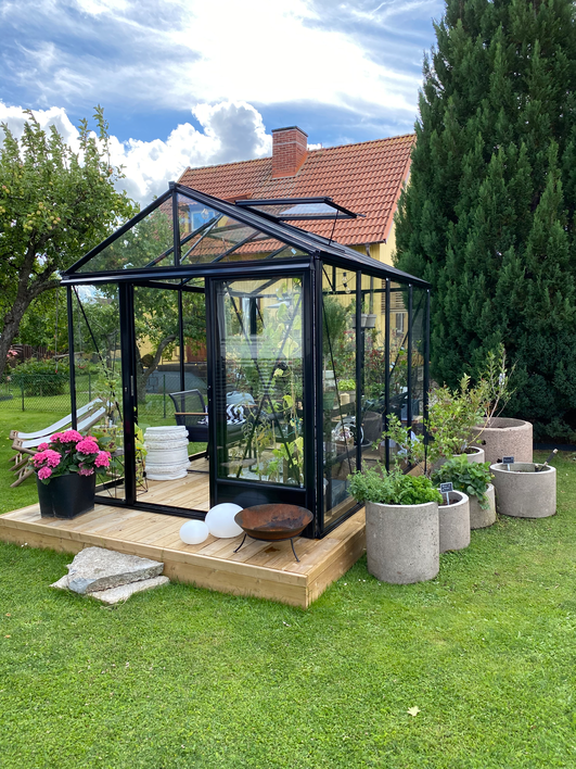 Euro Maxi Gewächshaus in Schwarz auf einem Holzdeck im Garten